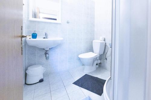 a white bathroom with a toilet and a sink at Belvederská chalupa in Železná Ruda