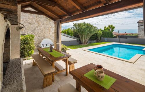 patio esterno con tavolo e piscina di 4 Bedroom Cozy Home In Dracevac a Dračevac
