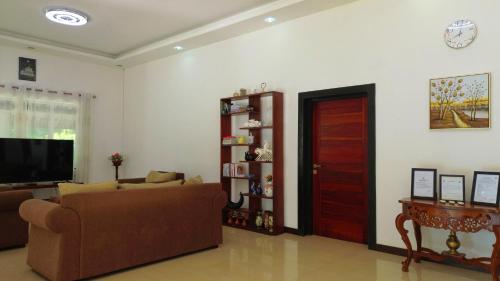 a living room with a couch and a tv and a door at Cogent Holiday Home in Gelioya