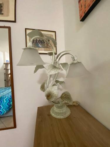 a vase with flowers on a table next to a mirror at Fazzoletto in Casalecchio di Reno
