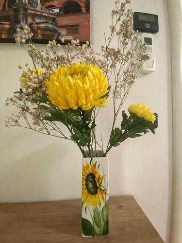 a vase filled with yellow flowers on a table at Fazzoletto in Casalecchio di Reno