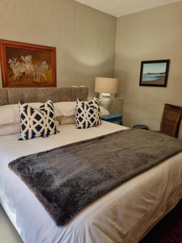 a bedroom with a large bed with blue and white pillows at Barrydale Karoo - BOUTIQUE HOTEL in Barrydale