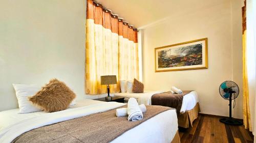 a room with two beds and a window at 87 Guesthouse in Baguio