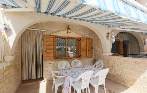 a patio with a table and chairs and a blue canopy at Gorgeous Home In Santa Pola With Wifi in Santa Pola
