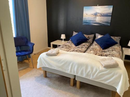 a bedroom with a large bed with blue pillows at Hammarö Vandrarhem in Hammarö