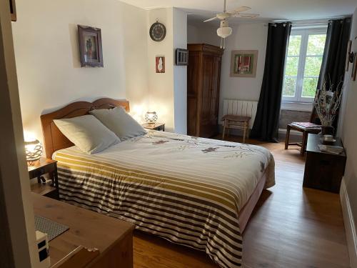 une chambre avec un grand lit dans une pièce dans l'établissement Les Agapanthes, à Vaux-en-Beaujolais