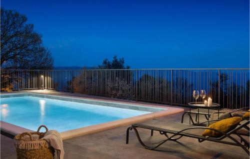 a swimming pool with two chairs and a table at Villa Lipa in Labin