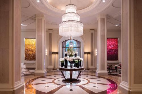 a lobby with a large chandelier and flowers on a table at Beverly Wilshire, A Four Seasons Hotel in Los Angeles