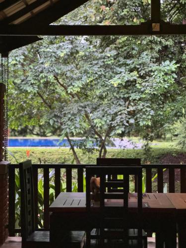 a table and chairs on a porch with a tree at Foresta Resort Sigiriya in Sigiriya