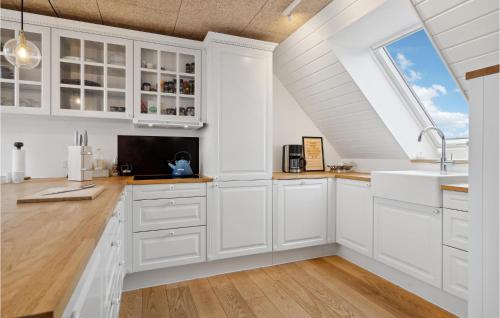 a white kitchen with white cabinets and a window at Awesome Home In Otterup With Jacuzzi in Otterup