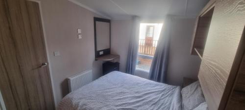 a small bedroom with a bed and a window at swift LOIRE in Evanton