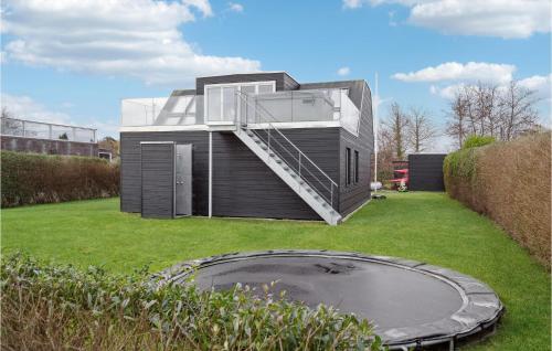 a modern house with a staircase on a yard at Awesome Home In Otterup With Jacuzzi in Otterup