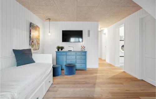 a bedroom with a bed and a blue dresser at Awesome Home In Otterup With Jacuzzi in Otterup