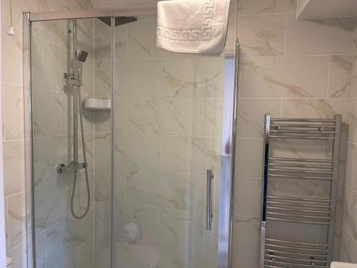 a bathroom with a shower with a glass door at Elegant Serviced Apartment with Parking in Oxford in Oxford