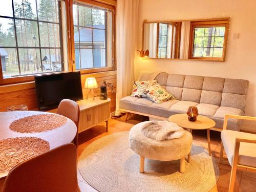 a living room with a couch and a table at Hippu Holiday Home in peaceful location near Äkäslompolo in Äkäslompolo