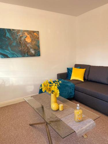 a living room with a couch and a glass table at Elegant Serviced Apartment with Parking in Oxford in Oxford