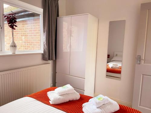 a bedroom with two towels sitting on a bed at Elegant Serviced Apartment with Parking in Oxford in Oxford