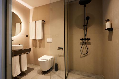a bathroom with a toilet and a glass shower at Bizarre Boutique Hotel in Varna City