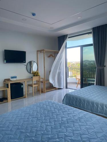 a hotel room with a bed and a balcony at Windy Homestay Phan Thiết in Phan Thiet
