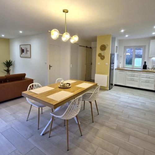a kitchen and dining room with a wooden table and chairs at Chill House - Maison 2 chambres - Option Jacuzzi in Chevannes