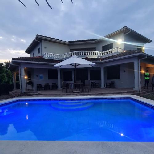 a villa with a blue swimming pool in front of a house at Marlin House in Kinondo
