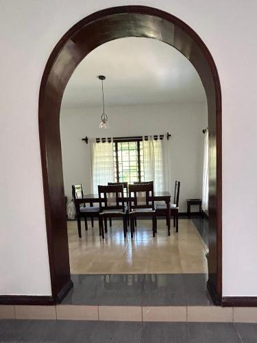 an archway in a dining room with a table and chairs at Marlin House in Kinondo