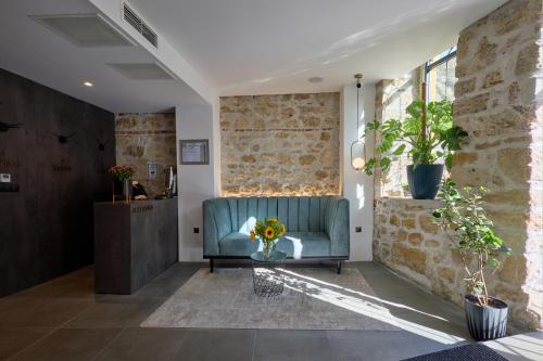 a living room with a blue couch and a brick wall at Bizarre Boutique Hotel in Varna City