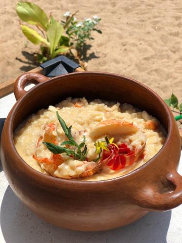 a bowl of soup with shrimp and vegetables in it at Pousada Maré Cheia in Itarema
