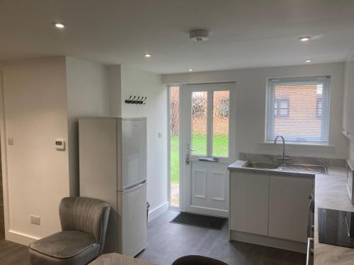 eine Küche mit einem Kühlschrank, einer Spüle und einem Stuhl in der Unterkunft The Stage Door in Slough