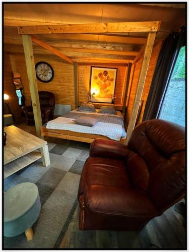 a bedroom with a bed and a couch and a clock at Ô Jardin Secret in Oberschaeffolsheim