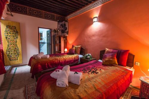 a bedroom with two beds with towels on them at Casa Aya Medina in F&egrave;s