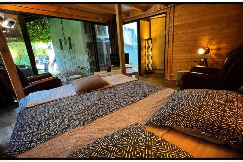 a large bed in a room with a large window at Ô Jardin Secret in Oberschaeffolsheim
