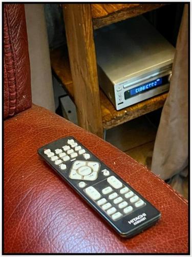 a remote control sitting on the arm of a chair at Ô Jardin Secret in Oberschaeffolsheim