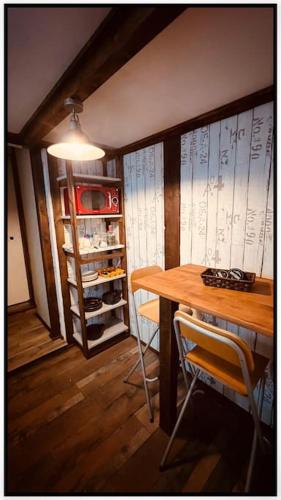 a dining room with a table and a book shelf at Ô Jardin Secret in Oberschaeffolsheim