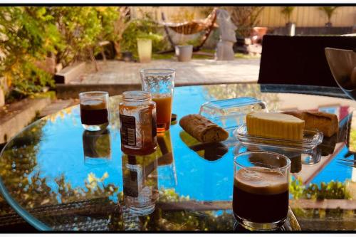 a glass table with some drinks and food on it at Ô Jardin Secret in Oberschaeffolsheim