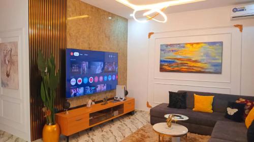 a living room with a couch and a flat screen tv at 3Bed Profssnal & Family Friendly with Swimming pool, Work Stns, PS5, Gym & near Beaches in Lagos