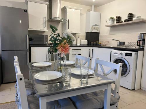 a kitchen with a table and chairs and a kitchen with a dishwasher at Lovely Serviced Apartment, Free Parking, Oxford in Oxford