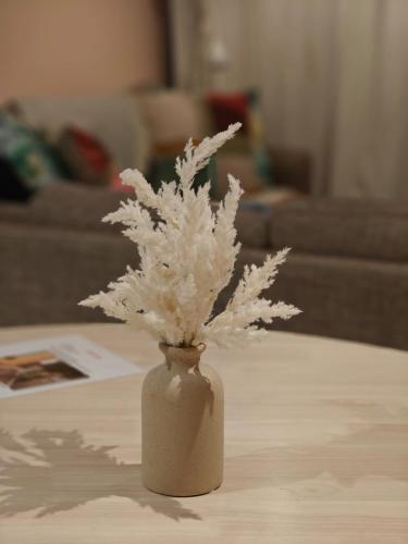 a vase filled with white flowers on a table at Luxury 2BR apartment in the heart of CBD in Adelaide