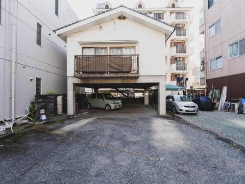 a parking lot in front of a building with a balcony at Tsuboi Eight in Kumamoto