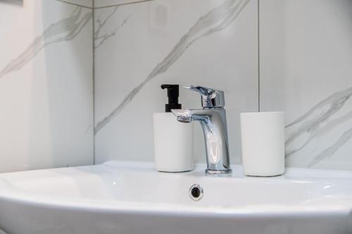 a bathroom sink with a faucet and two rolls of toilet paper at Flexible SelfCheckIns 110 - Zagreb - Private Parking - Loggia in Zagreb