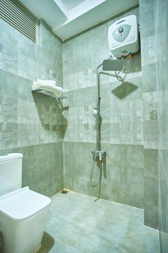 a bathroom with a toilet and a shower at The Retreat Minimum 3 Nights in Dehiwala
