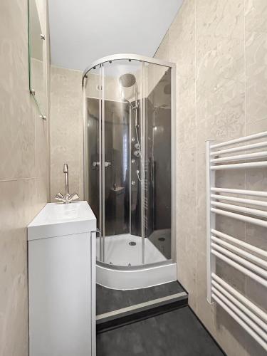 La salle de bains est pourvue d'une douche et d'un lavabo blanc. dans l'établissement Mezzanine, Terrasse privée et Clim, à Coulanges-lès-Nevers