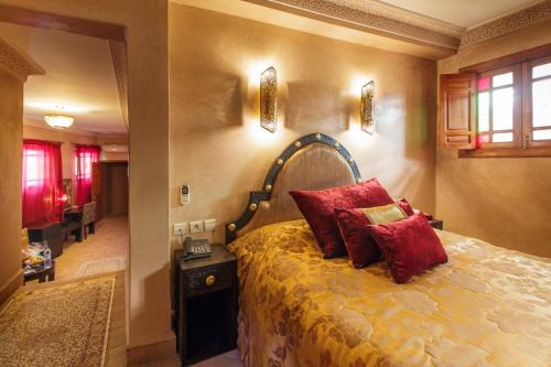 a bedroom with a bed with red pillows on it at Riad Andalib in Fès