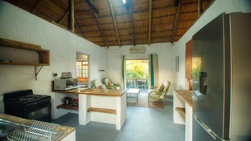 a kitchen with a table and a refrigerator in it at Lunamanzi Lodge in Manguzi