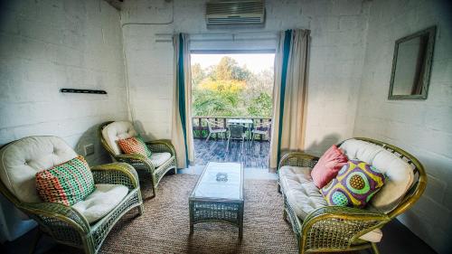 a living room with two couches and a table at Lunamanzi Lodge in Manguzi