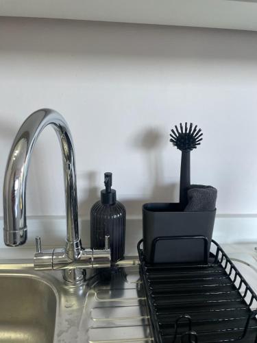 a kitchen sink with a dish drying rack next to a faucet at Castle View Apartments - The Hideout in Kendal