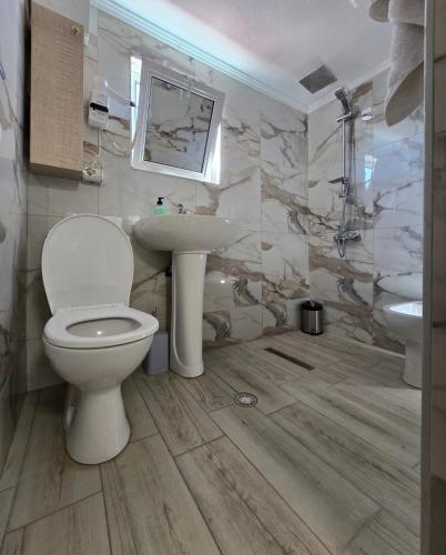 a bathroom with a toilet and a sink at Oasis in Korçë