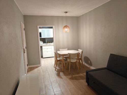 een woonkamer met een tafel, stoelen en een bank bij Lagoon House in Santiago do Cacém