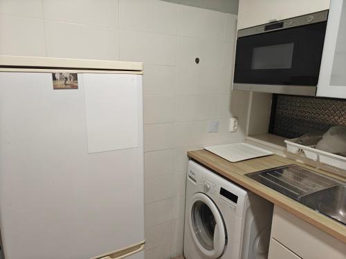 een keuken met een wasmachine en een magnetron bij Lagoon House in Santiago do Cacém