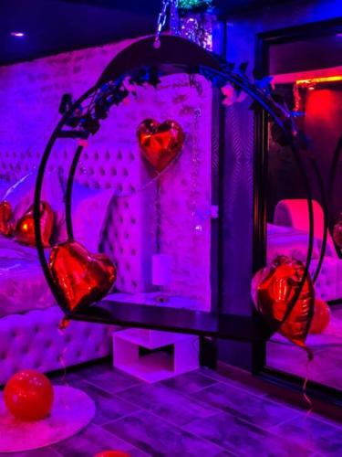a room with purple lights and hearts in a mirror at la nuit des passions avec petit déjeuner in Saint-Antoine